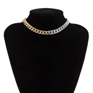 Close-up of gold and silver two-tone polished Cuban link chain on a black neck display