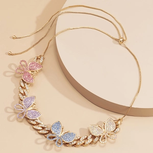 Detailed macro of gold Cuban link necklace featuring colorful crystal butterfly charms