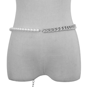 Detail of elegant waist chain with white pearls and polished silver metal links on a model