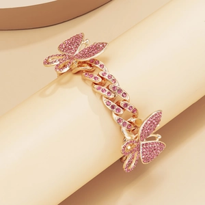 Close-up of golden Cuban link anklet with pink rhinestones and butterfly charms