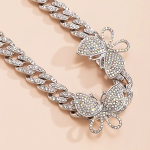 Close-up of hip-hop Cuban link anklet with silver-plated chain and sparkling AB crystal butterflies