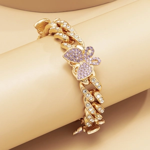 Detailed view of a gold Cuban anklet featuring a purple crystal butterfly pendant