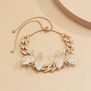 Detail of gold Cuban link anklet featuring sparkling rhinestone butterfly charms