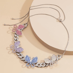 Detailed view of silver Cuban link necklace with four colorful rhinestone butterflies