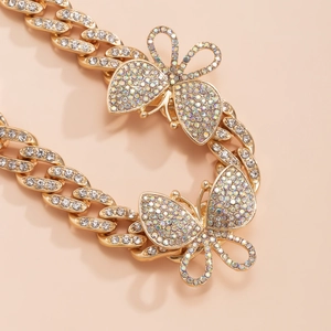 Close-up of golden Cuban link anklet with sparkling rhinestone-encrusted butterfly charms