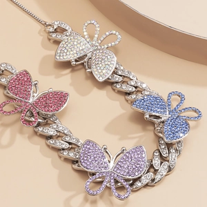 Macro shot of Cuban link necklace with colorful rhinestones and butterfly charms