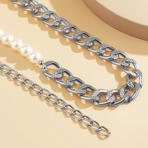 Detail of silver alloy waist chain with textured curb links and faux pearl accents