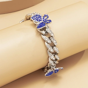 Detail of silver Cuban chain anklet with sparkling blue butterfly charms and white rhinestones