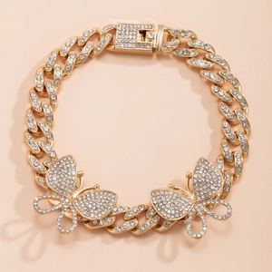Close-up of gold iced out Cuban link anklet with crystal butterfly charms and pave buckle