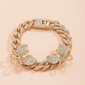 Detail of gold Cuban link anklet with large butterfly pendants and crystal pavé stones