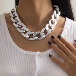 Grosse chaîne en métal argenté style punk portée par un mannequin sur un pull blanc