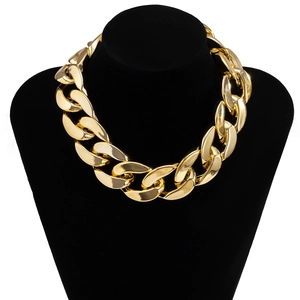 Gros plan d'un collier chaîne chunky doré exposé sur un buste en velours noir
