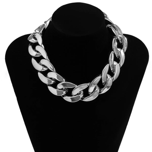 Gros plan d'un gros collier à maillons cubains punk argentés sur un buste en velours