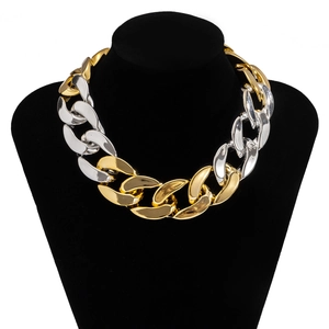Détail d'un collier chaîne bicolore or et argent sur un présentoir de mannequin noir