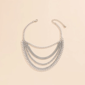 Close-up of layered silver metal multi-strand Cuban chain anklet with lobster clasp