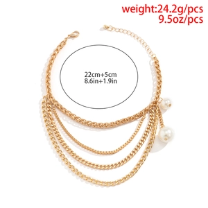 Detail of layered gold fringe anklet with white pearl accents and lobster clasp