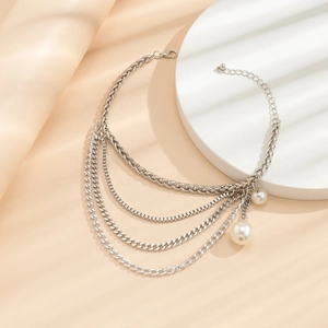 Detail of silver layered anklet featuring multiple chains and elegant pearl pendants