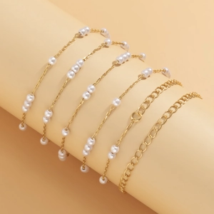 Dettaglio del set di 6 bracciali a catena dorata con perle su espositore