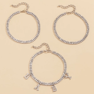 Detail view of silver layered anklet set with BABY letter pendants and crystals