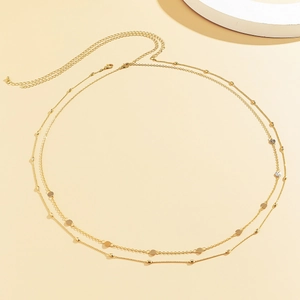 Close-up of double-layer gold chain belt featuring geometric discs and adjustable lobster clasp