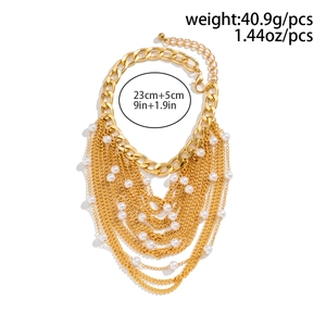 Detail showing multilayered gold tassel anklet with faux pearls and curb chain design