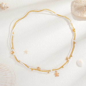 Détail d'une chaîne de taille multicouche avec pendentifs d'étoiles de mer et de conques