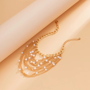 Detail of multilayered gold tassel necklace with white pearls and adjustable lobster clasp