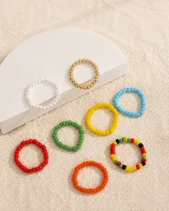 Detail von 8 gemischten böhmischen Perlen-Stretchringen auf strukturierter Steinfläche