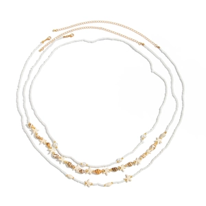 Détail de trois chaînes de taille bohème avec perles, étoiles de mer et coquillages