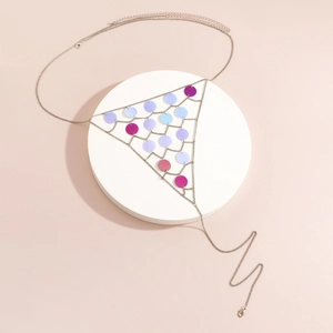 Detail of silver body chain with colorful sequins on minimalist white display