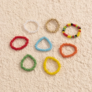 Detailansicht der bunten Perlenringe im Set mit elastischem Band und Goldperlen