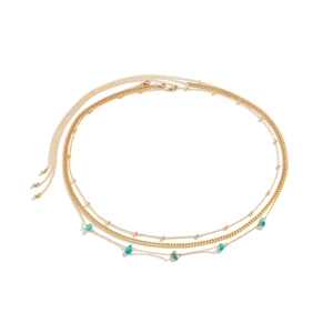Detailed view of bohemian gold waist chains with turquoise stones and layered curb links