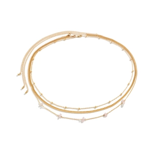 Detail of layered gold waist chain featuring pink stones and metallic beads jewelry
