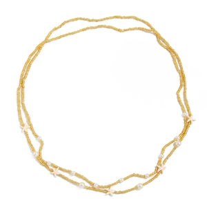 Détail d'une chaîne de taille double couche avec perles dorées et pendentifs étoile de mer