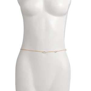 Dettaglio della catena in oro per la vita con perle barocche su manichino femminile