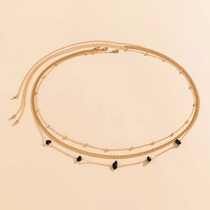 Close-up of layered gold waist chain featuring chunky link and black gravel stone accents