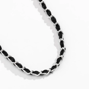 Detail of silver chain intertwined with black PU leather for fashion accessories