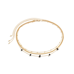 Detail of layered gold body chain featuring irregular black stones and adjustable clasp