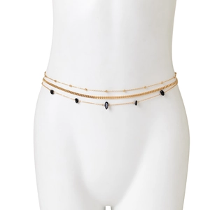 Detail view of multi-layered gold waist chain with black beads and bohemian charms