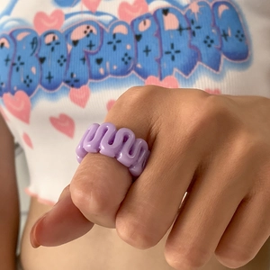 Close-up of a purple wavy resin ring featuring a minimalist cutout design on a model