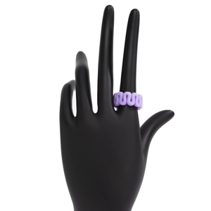 Macro detail of purple wave pattern resin ring displayed on a dark model hand