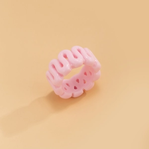 Close-up of a pink resin wave ring with a glossy finish and hollow wide-band design