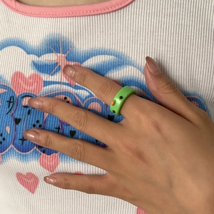 Nahaufnahme eines niedlichen 3D-Froschrings aus grünem Harz in lebhaften Macaron-Farben