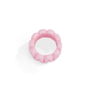 Macro detail of glossy pink resin ring featuring a trendy chunky wavy gear design