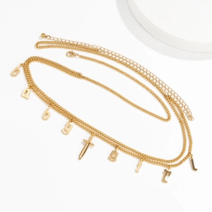 Detail of multi-layered gold waist chain with Baby Girl letters and dagger pendant