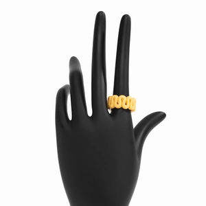Close-up of bright yellow resin ring with a wavy design on a black display hand