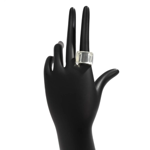 Gros plan d'une bague géométrique épaisse en résine transparente sur présentoir