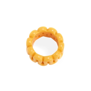 Macro view of chunky yellow resin ring featuring wavy texture and translucent finish