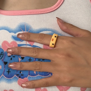 Nahaufnahme eines süßen 3D-Entenrings aus gelbem Harz, der am Finger getragen wird