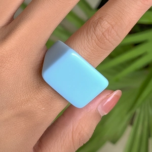 Gros plan d'une bague large en résine bleu clair au design géométrique pour un style épuré